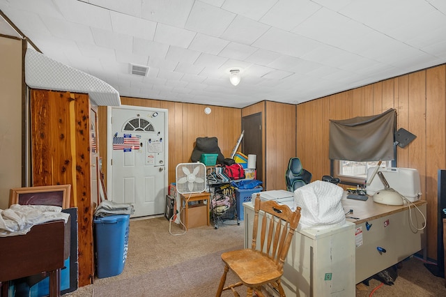 below grade area featuring wood walls, carpet flooring, and visible vents