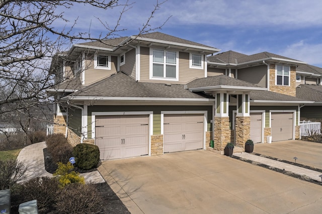 prairie-style home with concrete driveway, a shingled roof, and an attached garage