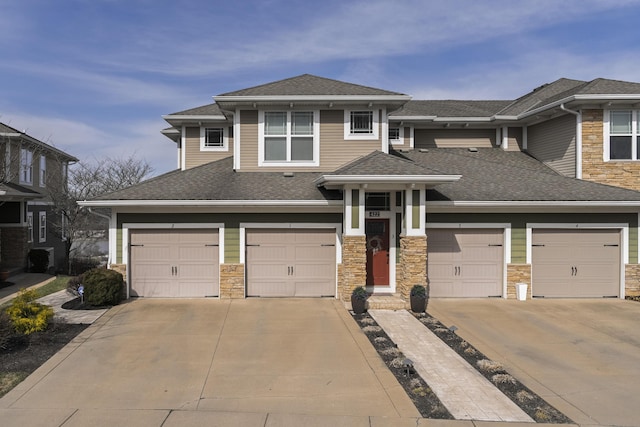 prairie-style home featuring driveway, a shingled roof, and stone siding