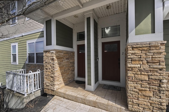 entrance to property with stone siding and covered porch