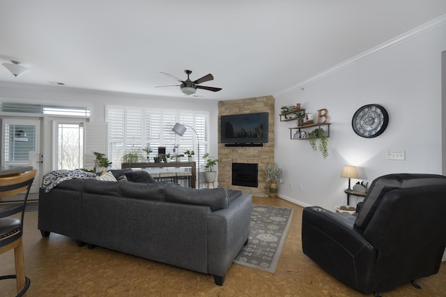 living room with ornamental molding, a fireplace, plenty of natural light, and a ceiling fan