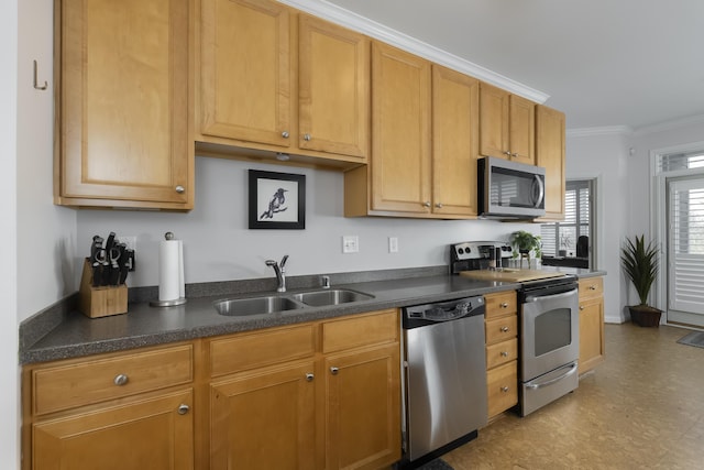 kitchen featuring appliances with stainless steel finishes, dark countertops, crown molding, and a sink