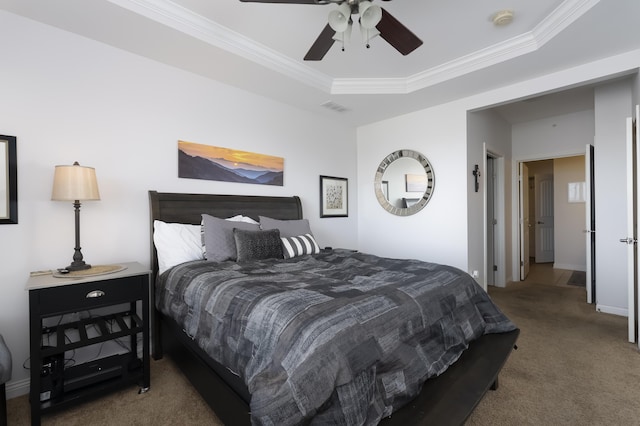 carpeted bedroom with ceiling fan, a raised ceiling, visible vents, and crown molding