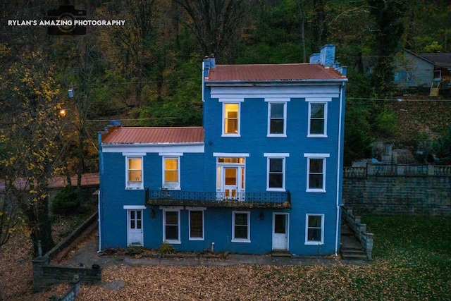 view of front of house featuring metal roof and stairs