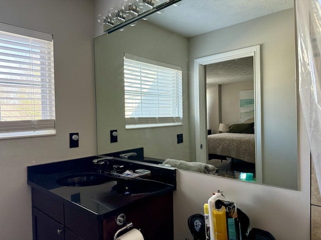 bathroom with vanity, connected bathroom, and a textured ceiling