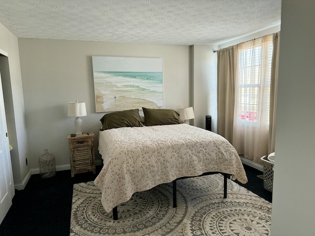 bedroom with a textured ceiling and baseboards