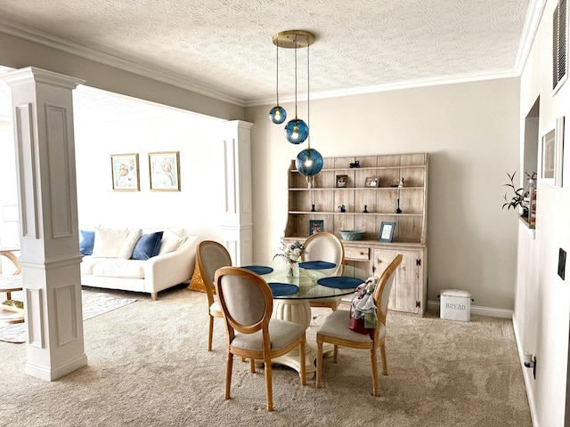 carpeted dining space featuring baseboards, a textured ceiling, ornamental molding, and ornate columns