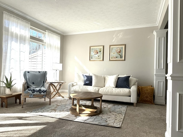 living area with a textured ceiling, decorative columns, carpet floors, and ornamental molding