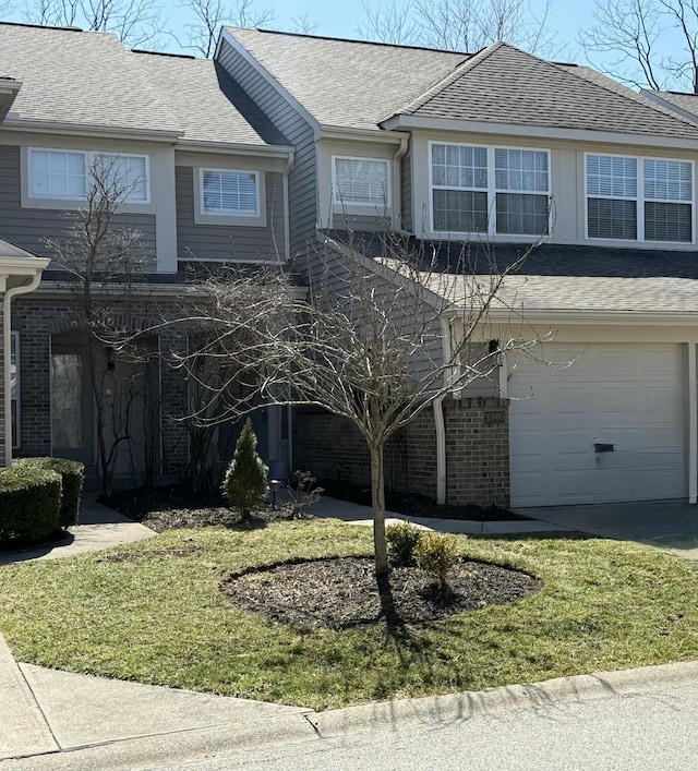 view of front of property featuring a front yard, a garage, brick siding, and a shingled roof