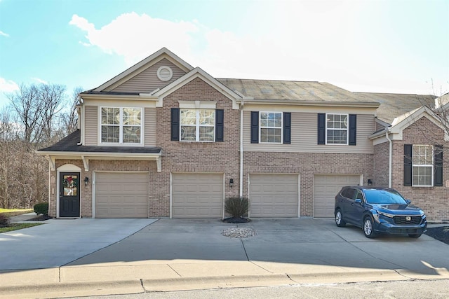 view of front of house with an attached garage, brick siding, and driveway