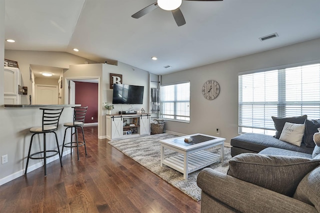 living area featuring visible vents, ceiling fan, baseboards, lofted ceiling, and dark wood-style flooring