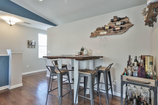 interior space featuring vaulted ceiling, dark wood-style floors, visible vents, and baseboards