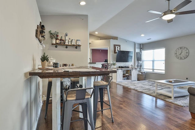 dining area with dark wood-type flooring, a ceiling fan, recessed lighting, baseboards, and vaulted ceiling