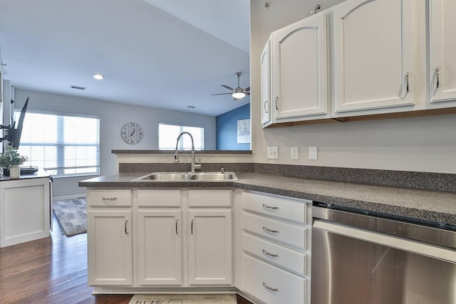 kitchen featuring a sink, dark countertops, dishwasher, and white cabinets