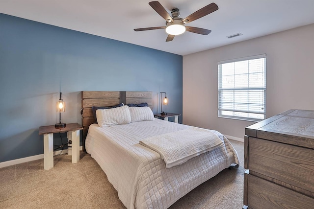 bedroom featuring visible vents, baseboards, light colored carpet, and a ceiling fan