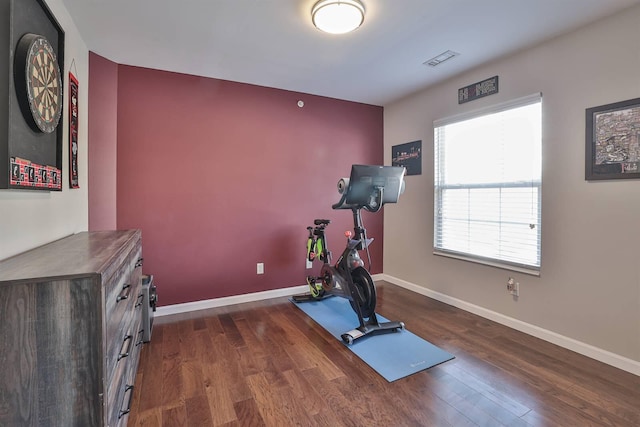 workout room featuring visible vents, baseboards, and dark wood-style floors