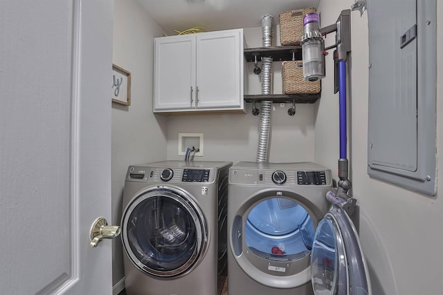 laundry area with washing machine and dryer, electric panel, and cabinet space