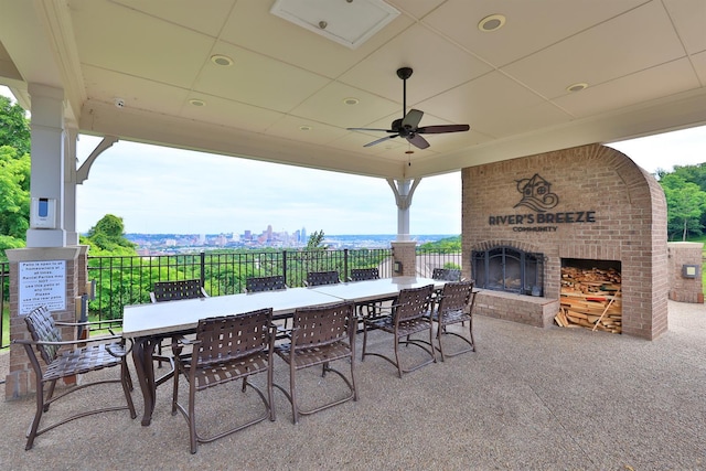 view of patio / terrace featuring outdoor dining area, fence, and an outdoor brick fireplace