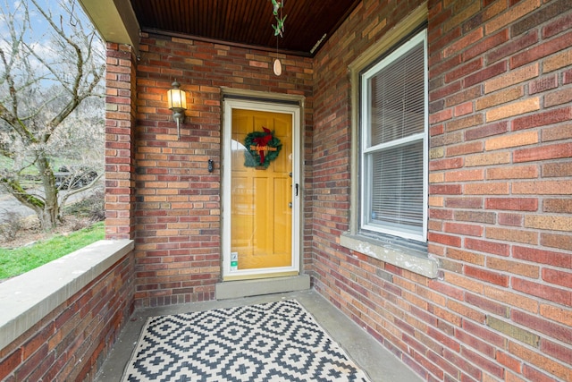 view of exterior entry featuring brick siding