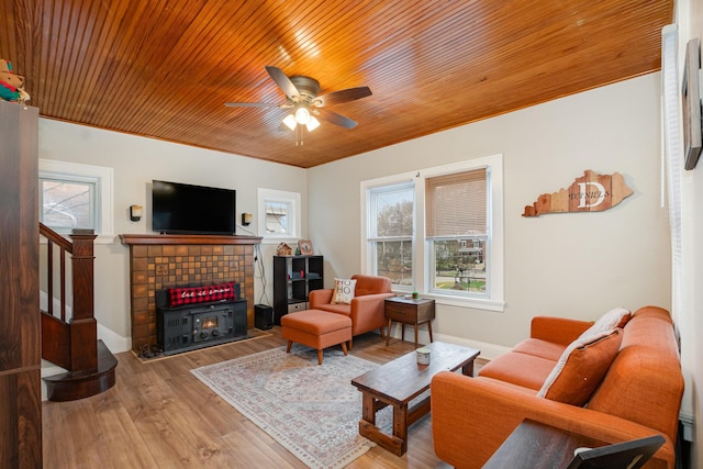 living area featuring wood finished floors, wood ceiling, a ceiling fan, stairs, and baseboards