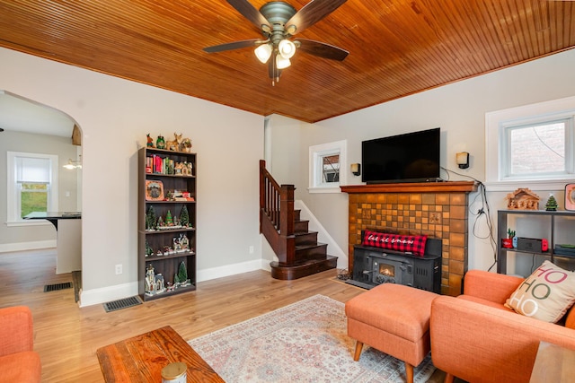 living room featuring arched walkways, wood finished floors, wood ceiling, visible vents, and stairs