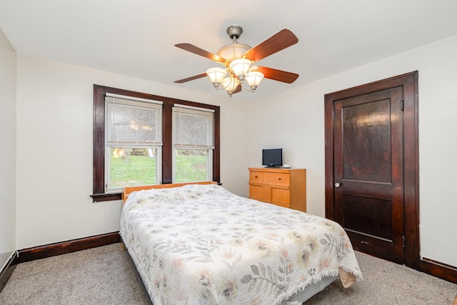 carpeted bedroom featuring baseboards and a ceiling fan