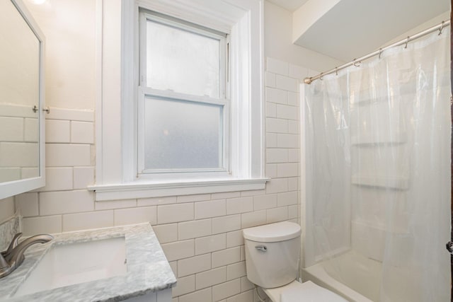 full bath featuring toilet, a shower with shower curtain, vanity, and tile walls