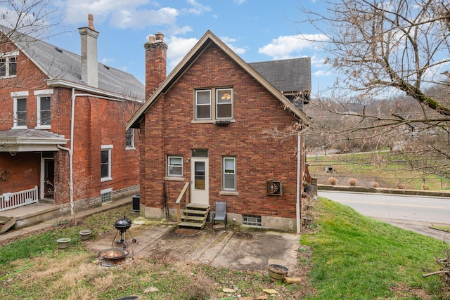 back of house with entry steps, brick siding, and central AC unit