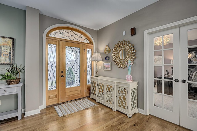 foyer with french doors, baseboards, and wood finished floors