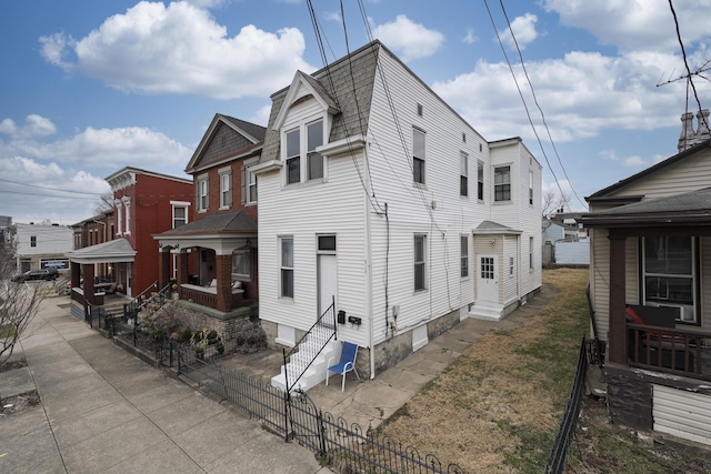 view of side of home featuring entry steps and fence