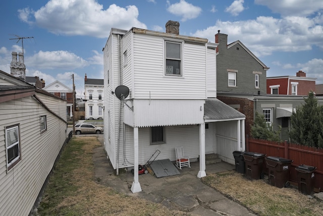 rear view of property featuring entry steps and fence