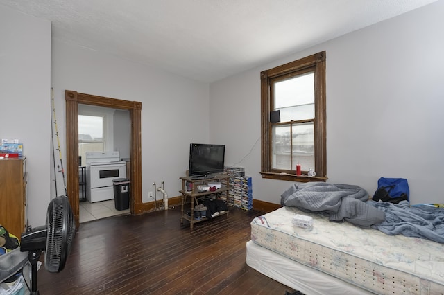 bedroom featuring baseboards, wood-type flooring, and connected bathroom