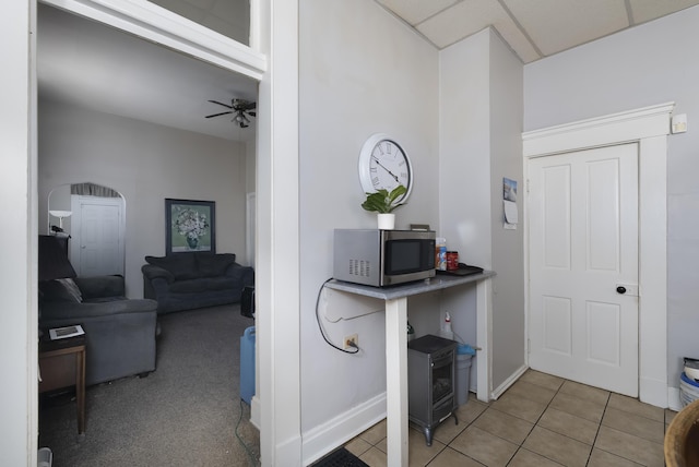 interior space with baseboards, ceiling fan, and tile patterned flooring