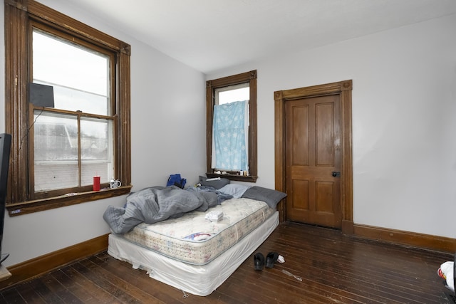 bedroom with hardwood / wood-style floors and baseboards