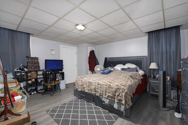 bedroom featuring a paneled ceiling and wood finished floors