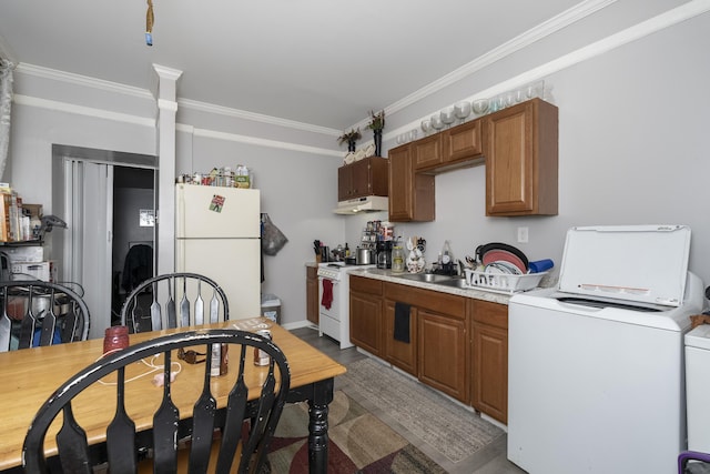 kitchen with ornamental molding, under cabinet range hood, white appliances, light countertops, and washer / dryer