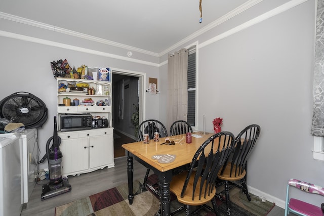 dining area with baseboards, dark wood-type flooring, washing machine and dryer, and ornamental molding