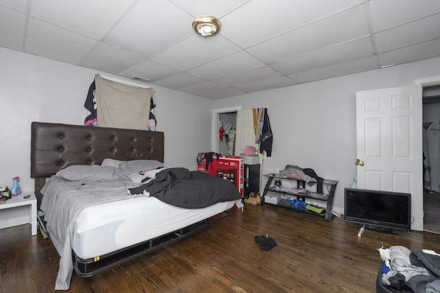 bedroom with a drop ceiling and wood finished floors