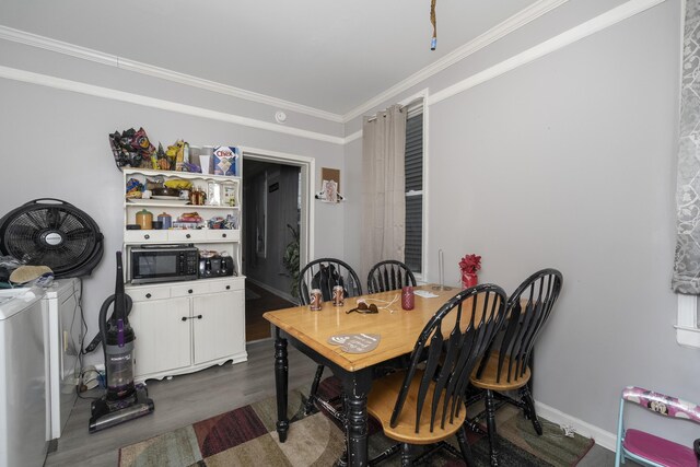 dining room with baseboards, washing machine and dryer, dark wood-style flooring, and ornamental molding