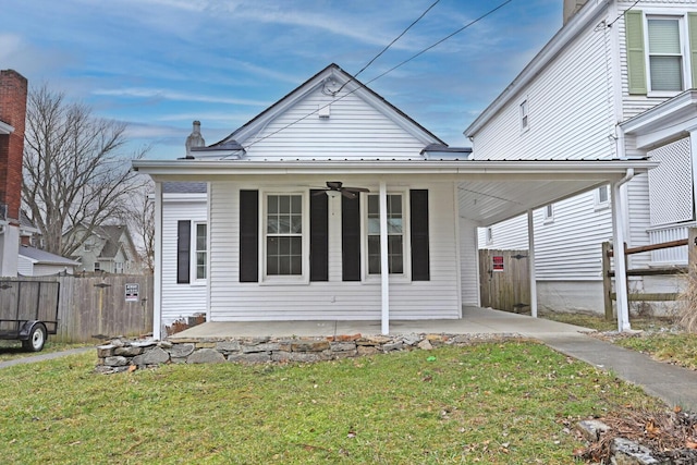 view of front of house with metal roof, fence, and a front lawn