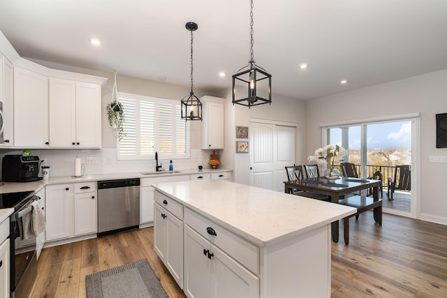 kitchen with dishwasher, light wood-style flooring, backsplash, black electric range, and a sink