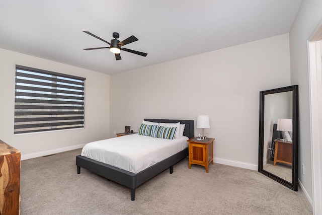 bedroom with light carpet, visible vents, a ceiling fan, and baseboards