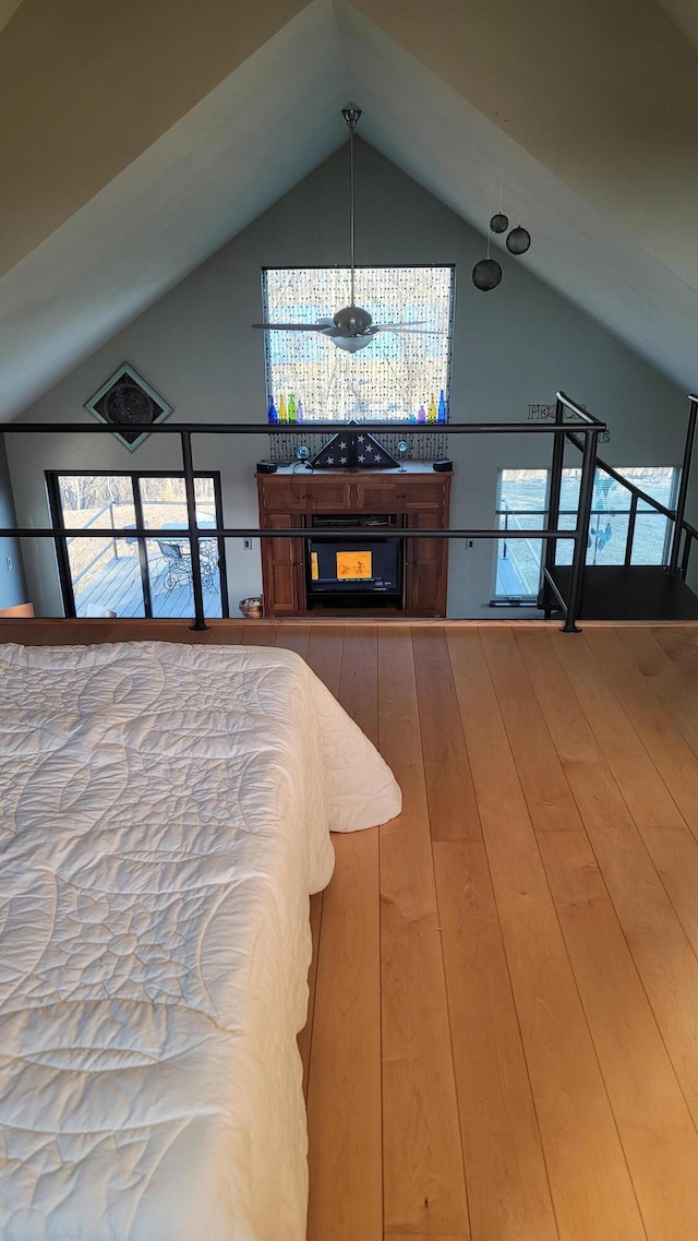 bedroom featuring lofted ceiling, multiple windows, and wood finished floors