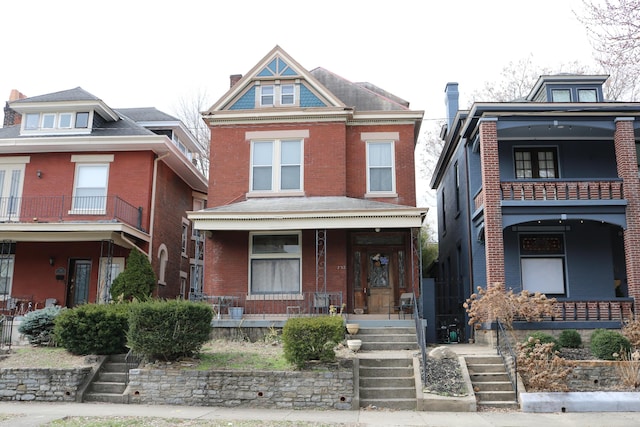 view of front of home with covered porch and brick siding