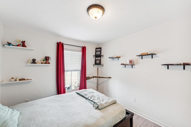 bedroom featuring baseboards and wood finished floors