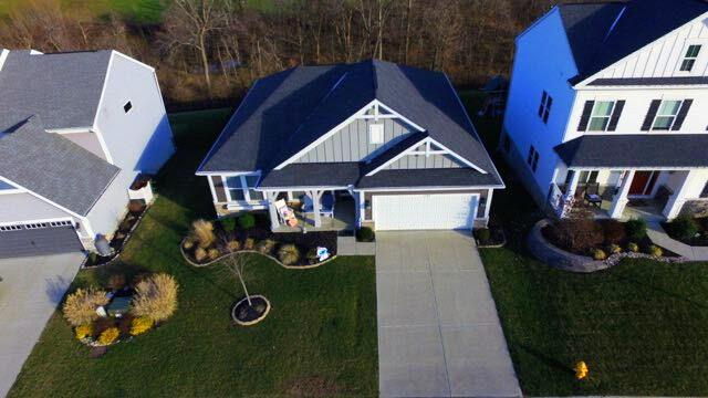 view of front of house with concrete driveway, an attached garage, board and batten siding, and a front yard