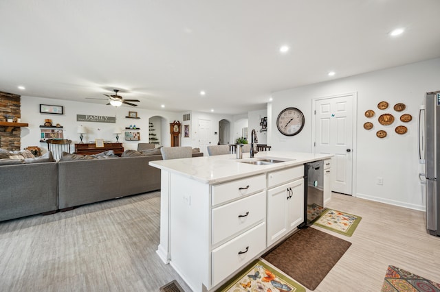 kitchen with recessed lighting, arched walkways, stainless steel appliances, a sink, and white cabinetry