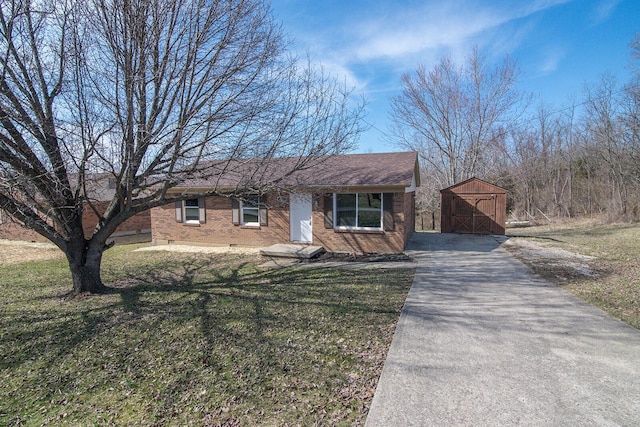 view of front of home with a front lawn, an outbuilding, and brick siding