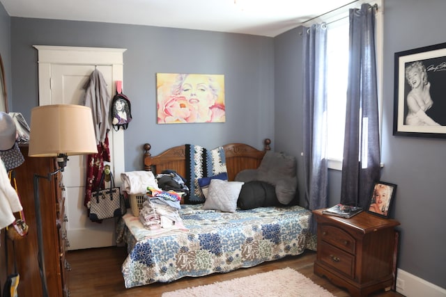 bedroom with baseboards and wood finished floors