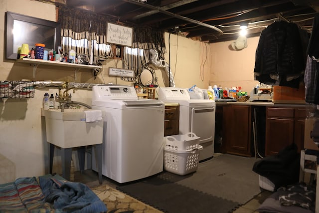 washroom with a sink, cabinet space, and washing machine and dryer